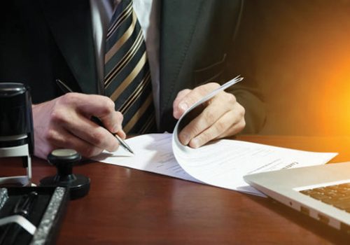 A businessman puts his signature on the contract